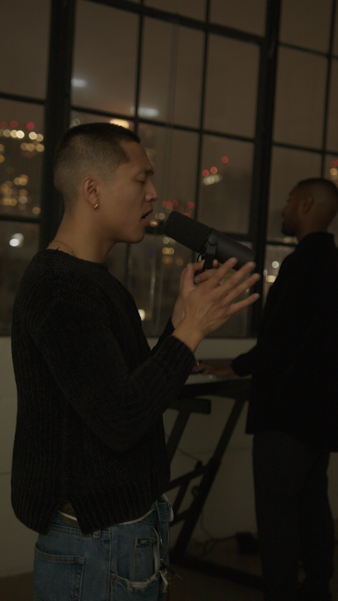 Behind the scenes — vocalist close-up with city lights